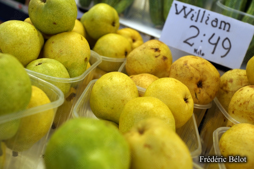 Des poires jaunes et vertes présentées sur un étal, étiquette "William".