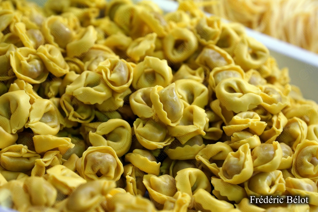 Des tortellini frais présentés en vrac sur un étal.