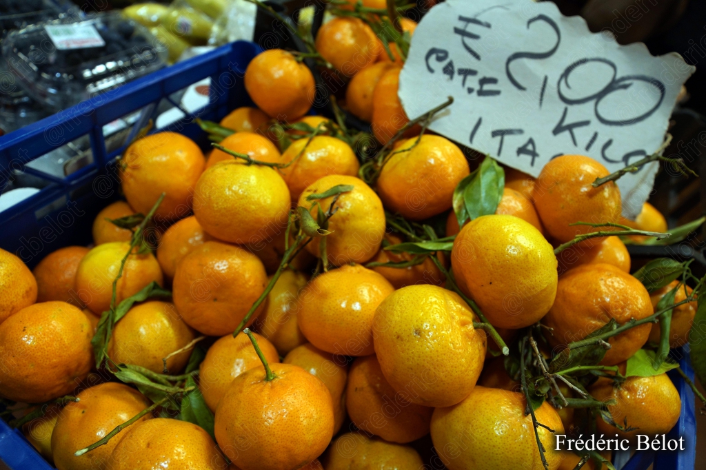Des mandarines fraîches présentées en caisse, étiquette de prix.