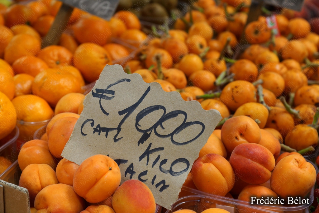 Des abricots frais présentés en vrac, étiquette de prix.