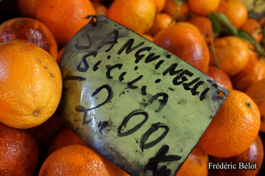 Des oranges siciliennes présentées en tas, étiquette manuscrite.