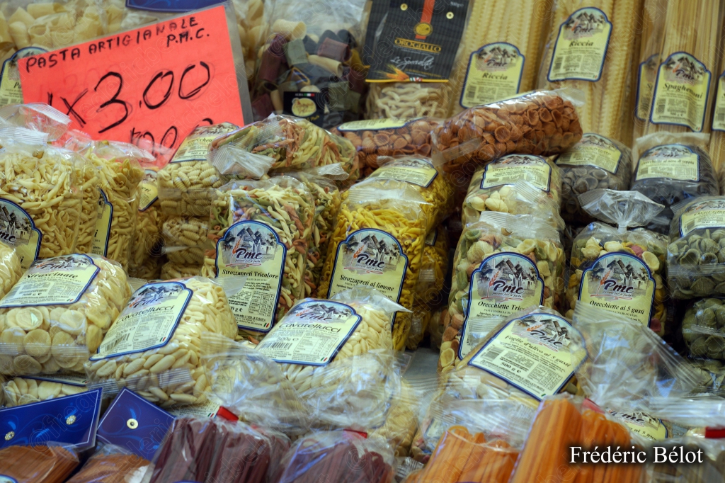 Des pâtes artisanales emballées présentées sur un étal, étiquette de prix.