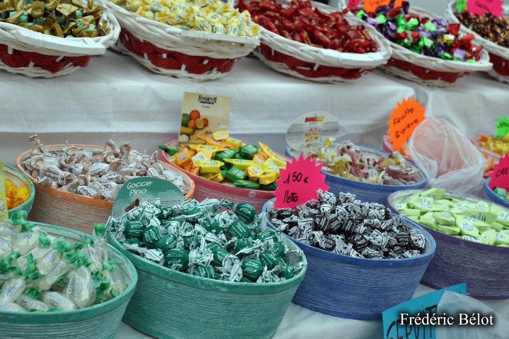 Un étal de confiseries et chocolats variés dans des bacs colorés.