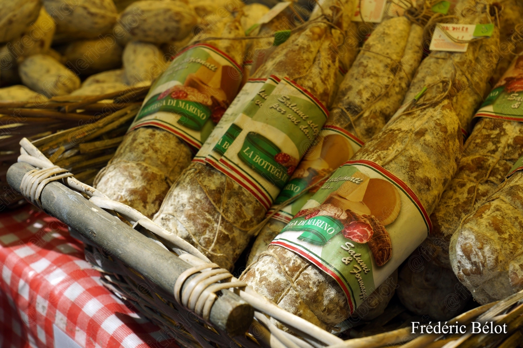Des saucissons secs présentés en gerbe sur un étal.