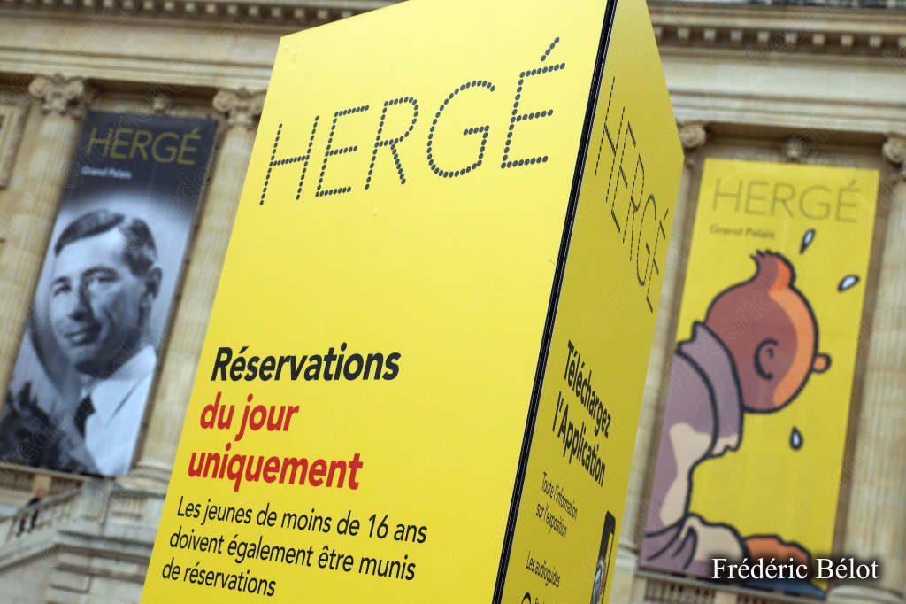 Un cube signalétique "Hergé" jaune indique l'entrée et les réservations du jour.