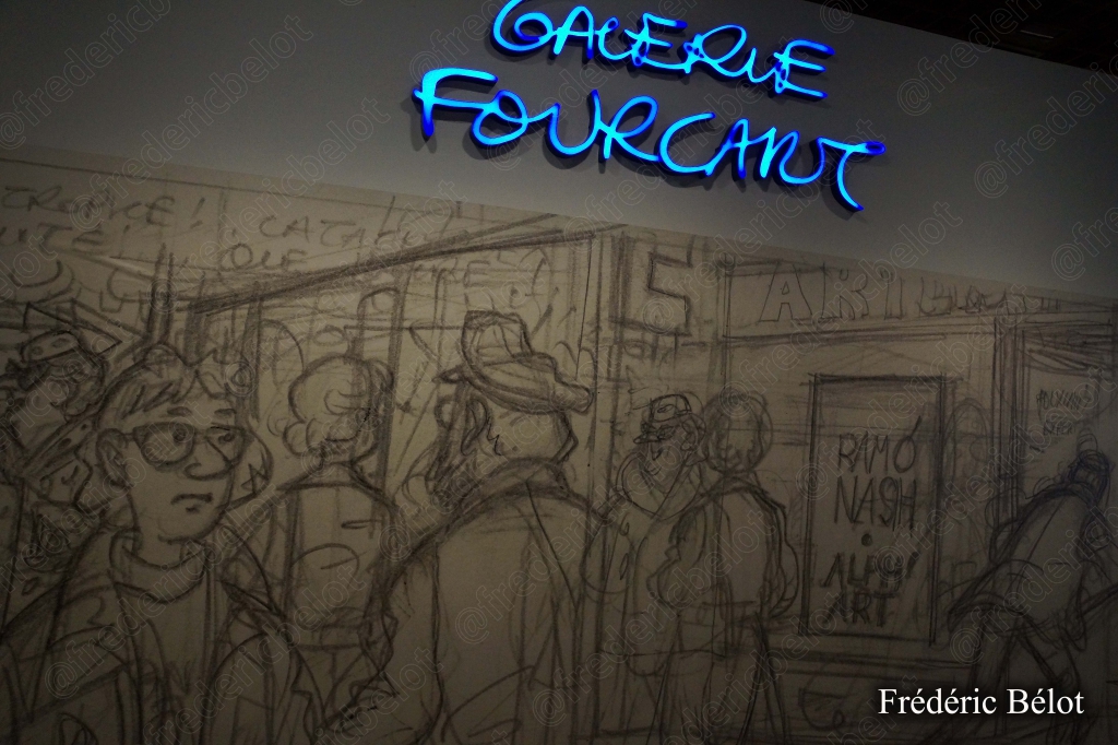 Une enseigne néon bleue "Galerie Fourcaut" éclaire un mur couvert de dessins préparatoires.