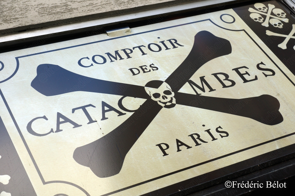 L'enseigne historique "Comptoir des Catacombes Paris", ornée d'un crâne et de tibias croisés.